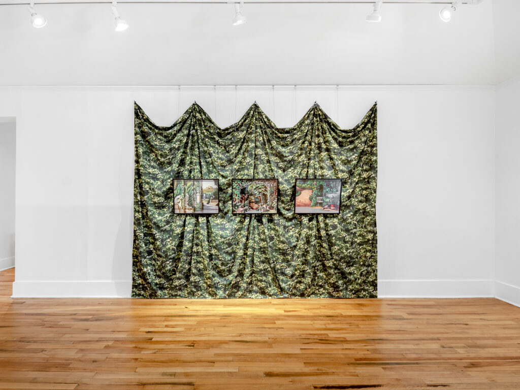 A photograph of an installation on a white wall in a gallery with a wooden floor and a doorway to the left. The installation consists of three medium sized photographs of paper theaters composed of manicured Victorian gardens all hanging in front of a draped curtain with a dense leaf pattern.