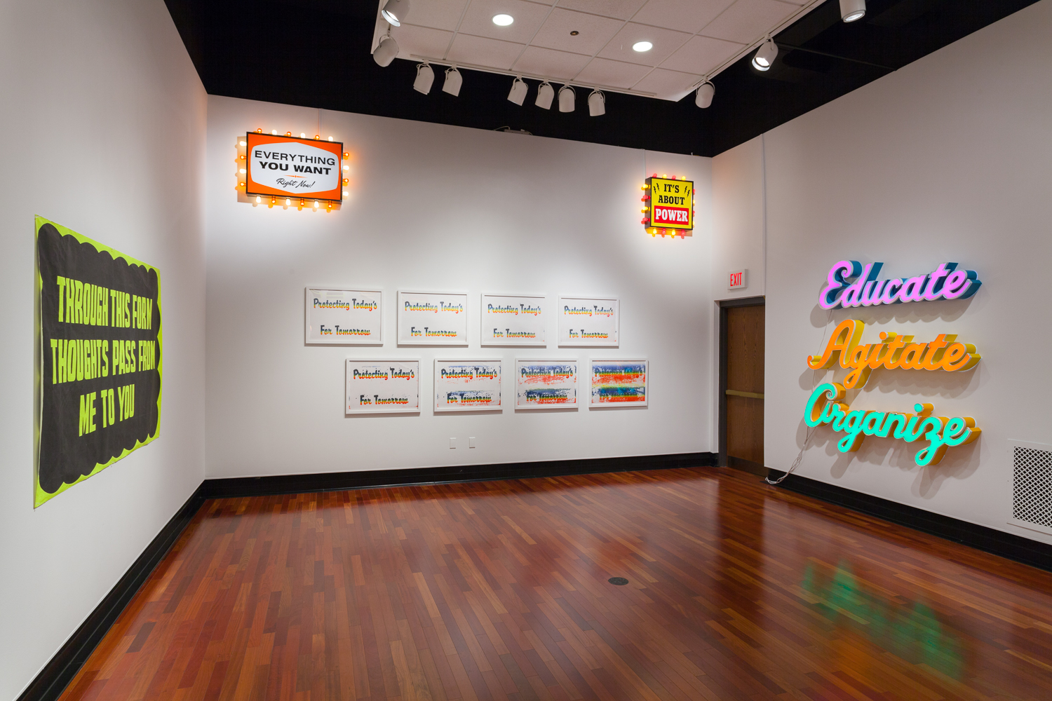 Gallery installation view of artworks that are reminiscent of billboards and posters