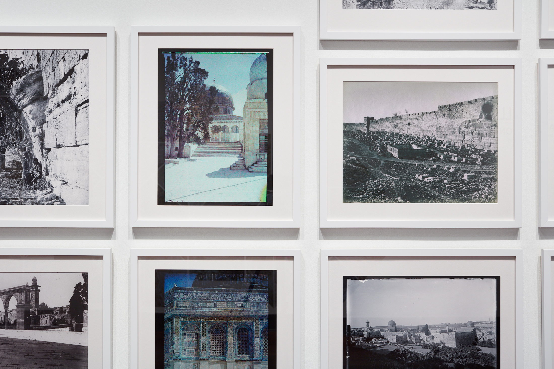 Various white framed exterior photographs of architecture, some in black-and-white, some in color.