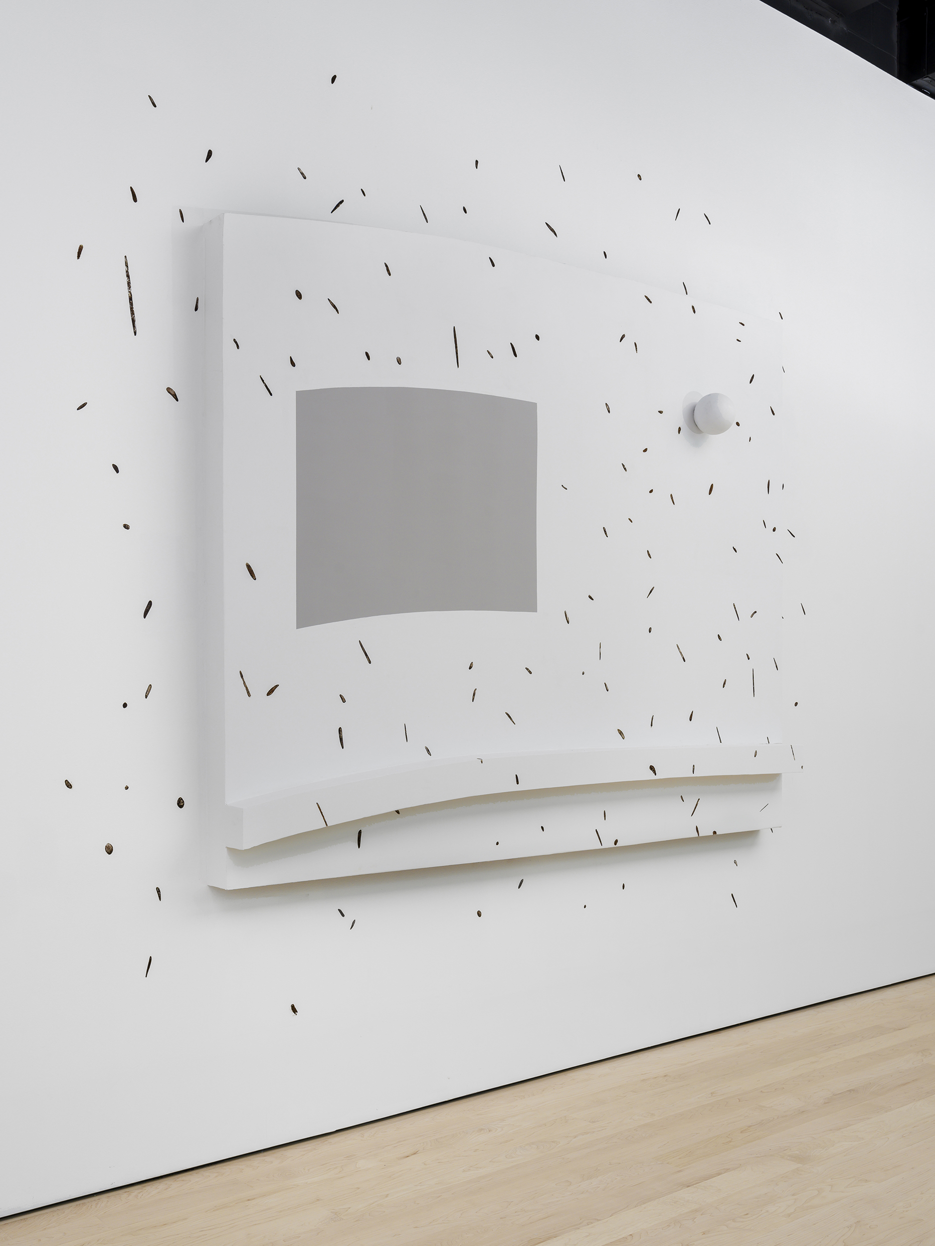 Installation view of an abstract rectangular artwork protruding slightly from the wall, entirely white with a smaller grey rectangle and covered in black dashes that spill onto the wall.