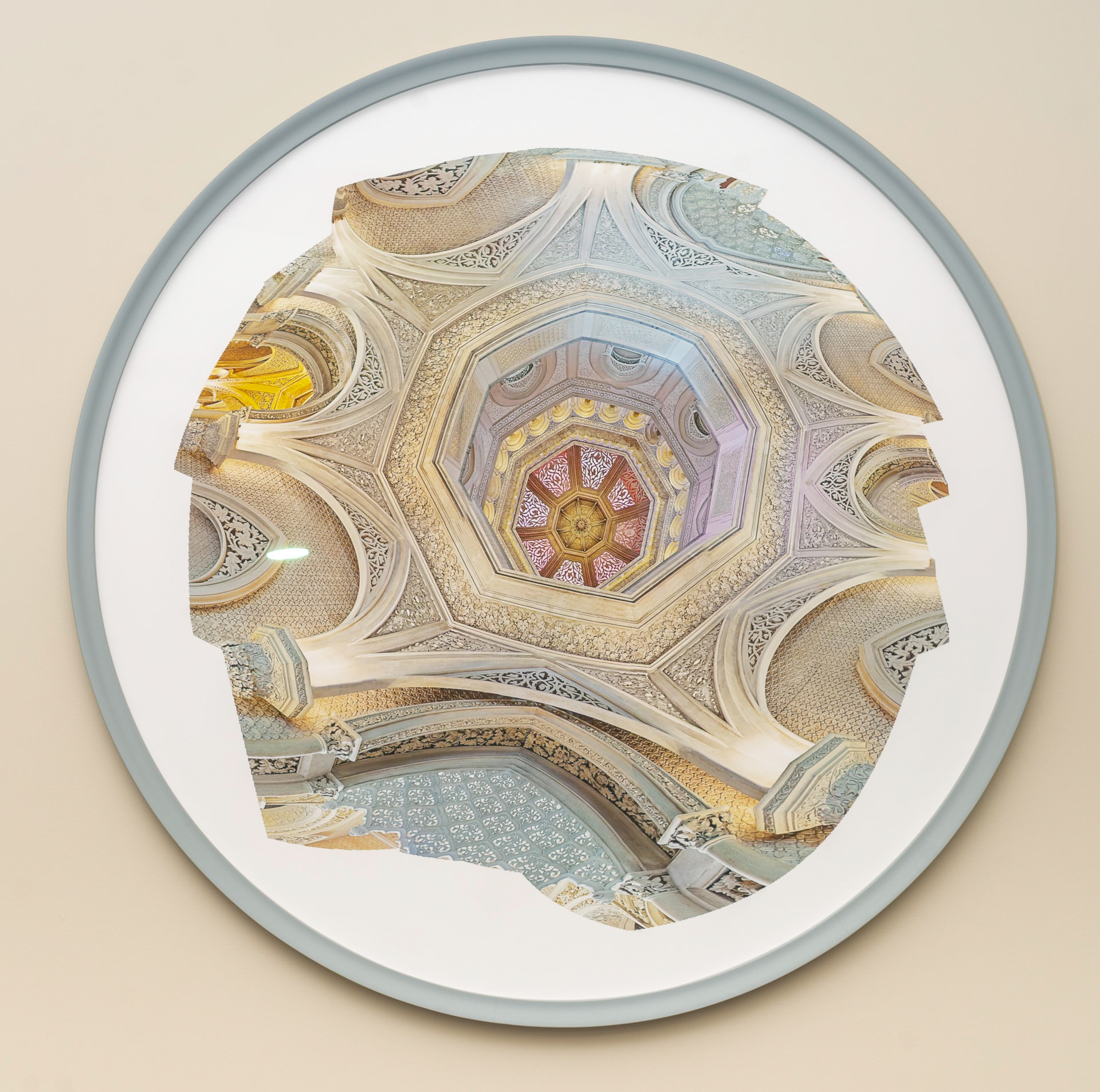 A golden dome with red, gold, purple, and blue details, surrounded by soft beige arches and fine carved patterns.