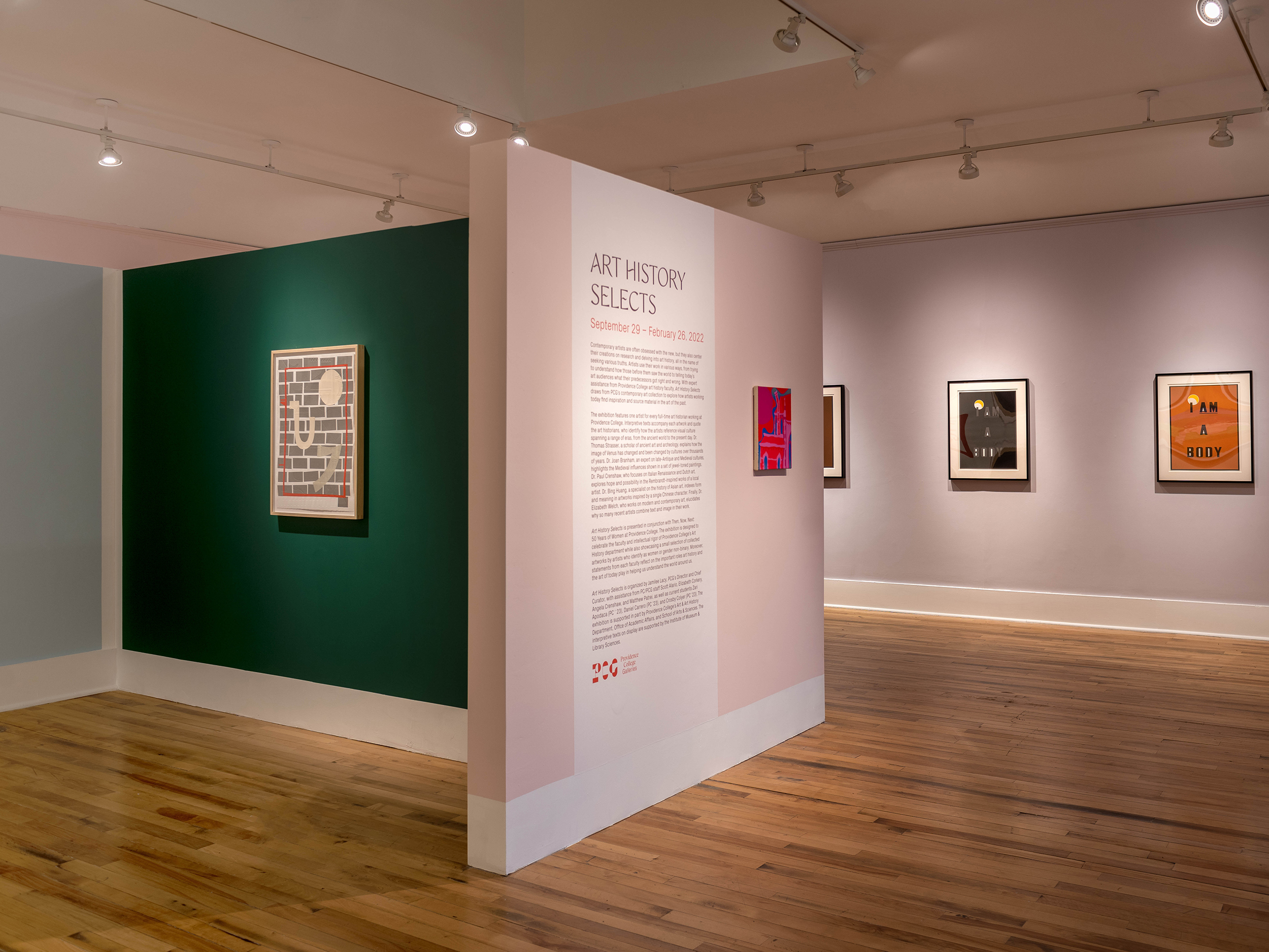 Installation view of a T shaped wall with one portion painted pink with text including: Art History Selects, and the other portion dark green with a singular artwork.