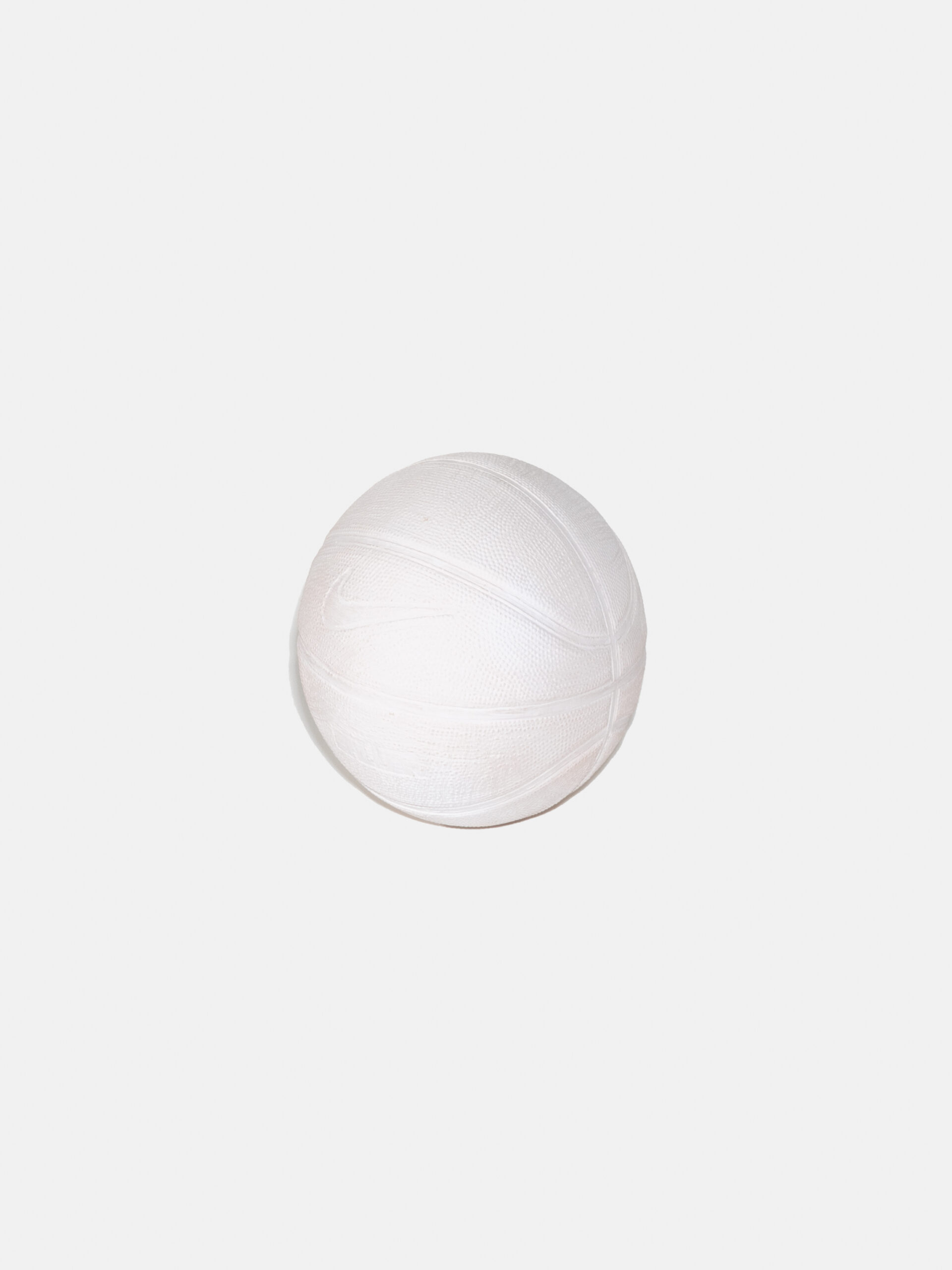 An entirely white basketball on a white background. The indentations of lines and the Nike swoosh logo are visible.
