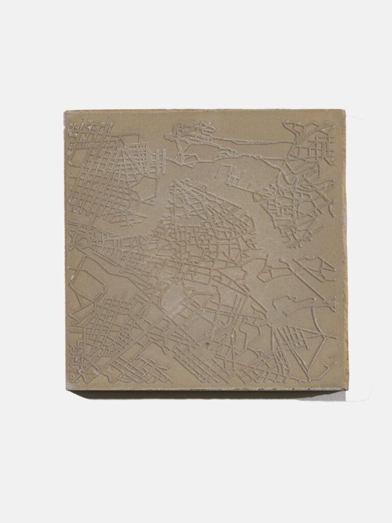 A light brown square is covered in crisscrossing lines that are slightly raised. Some of the lines form grids while others branch out in different directions.