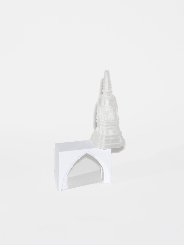 A 3D white rectangle with a cut out of a pointed holds up the top of a white tower. The tower sits on the edge of the rectangle.