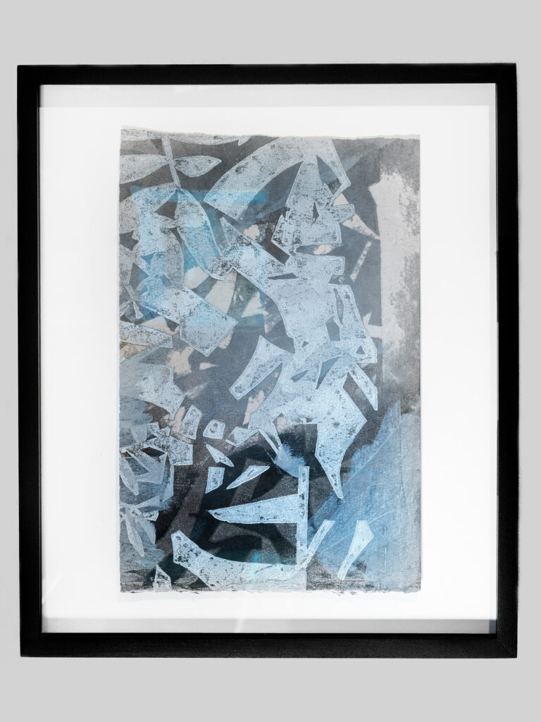 An abstract print referencing plant life in varying shades of blues and blacks in a black frame.