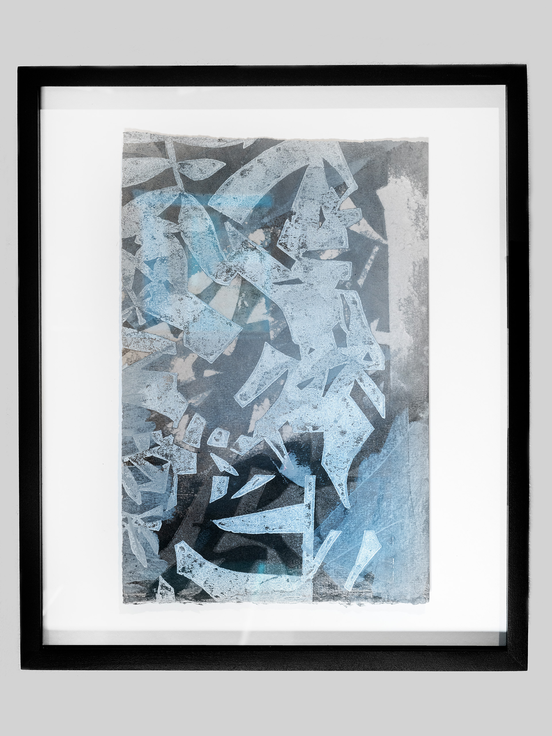 An abstract print referencing plant life in varying shades of blues and blacks in a black frame.