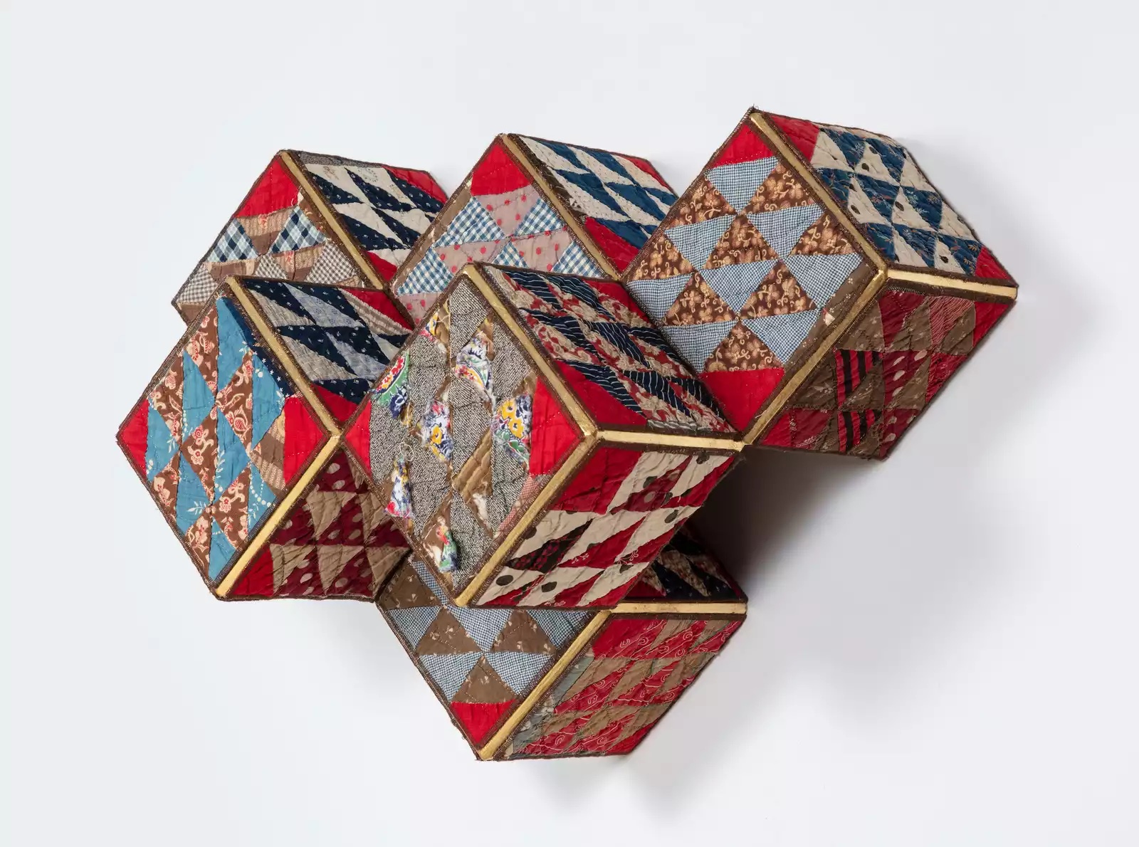 Six cubes attached to each other made up of blue, red, gray, black, and brown triangles of abstract shapes.