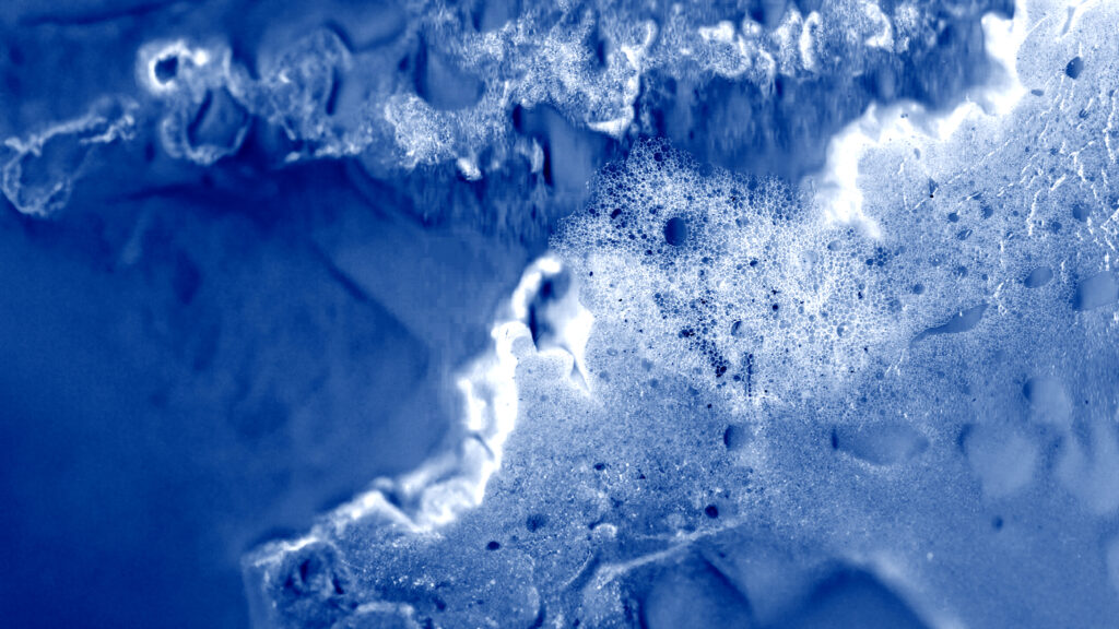 Abstract white and blue shapes, vaguely resembling waves with air bubbles.